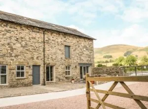 image of Boskins holiday cottage, a converted barn with the Howgills in the background
