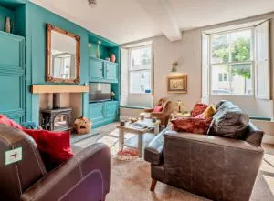 image of the interior of a lake District pet friendly cottage showing brown leather sofas in front of a wood burner.