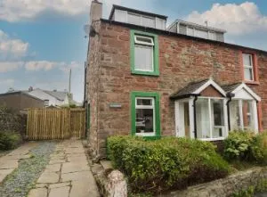 image of the front of a sandstone end-terrace pet friendly cottage in Cumbria