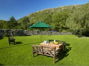 Garden with picnic bench and mountain views at Scafell Cottage in Eskdale