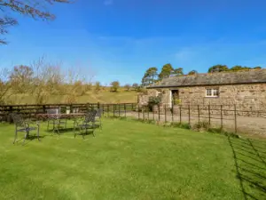image of the exterior of a wheelchair accessible cottage in the Lake District with Scots Pine trees behind a slate roof