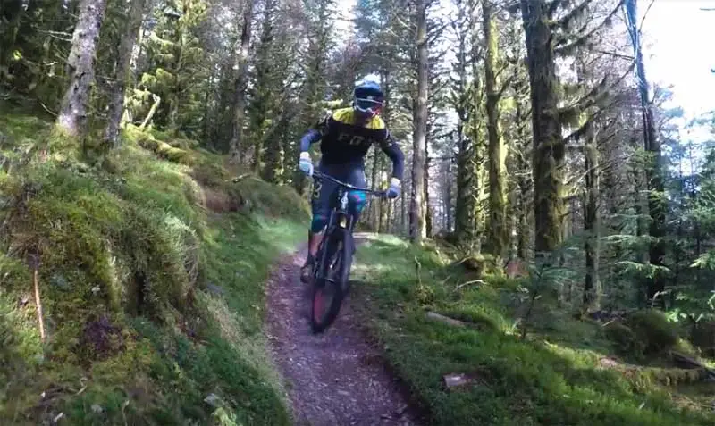 image of a person, in helmet, riding a mountain bike downhill on the Altura Trail at the Whinlatter Forest Park