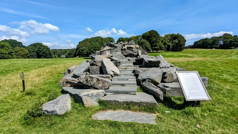 image of The Julie Brook installation at Holker Hall, a staircase like structure made out of stone in the deer park.