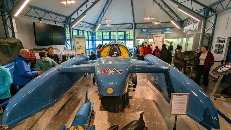 image of Donald Campbell's boat Bluebird, photo shows a small crowd gathered around the boat.