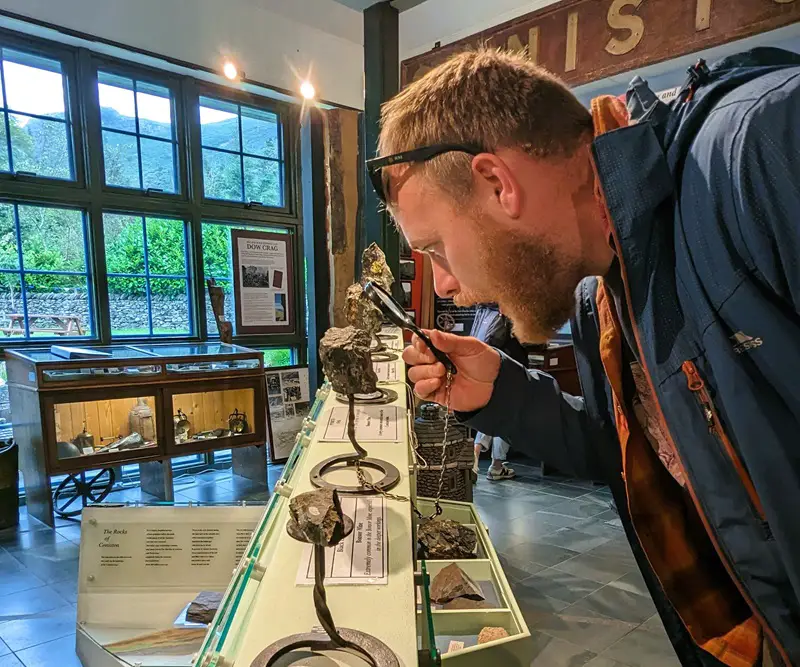 image of a very handsome gentleman looking at some minerals through a magnifying glass