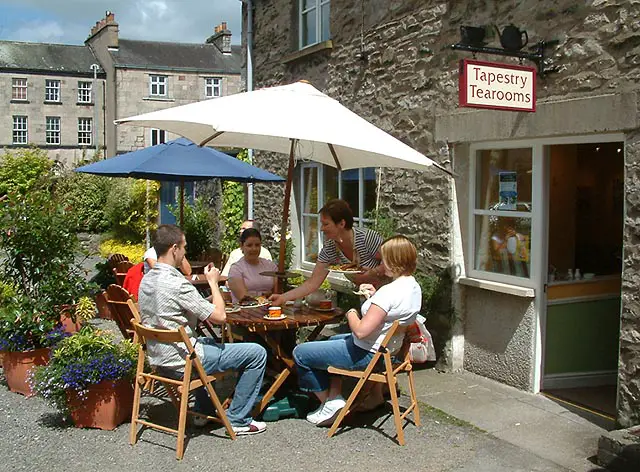 image of people sitting around a table outside Quaker Tapestry Museum tea shop