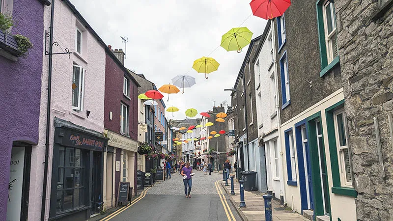 image of a street in Ulverston, in Cumbria, with brightly coloured umbrellas suspended over the street