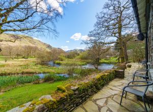 image of a view from a lake district cottage looking over hills and a lake
